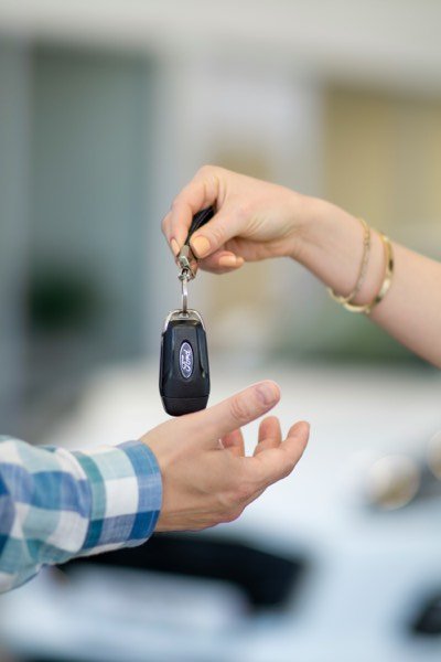 A set of car keys handed from one person to another